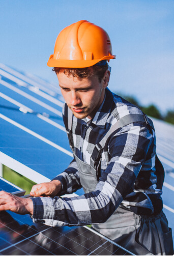 man installs solar panels on roof