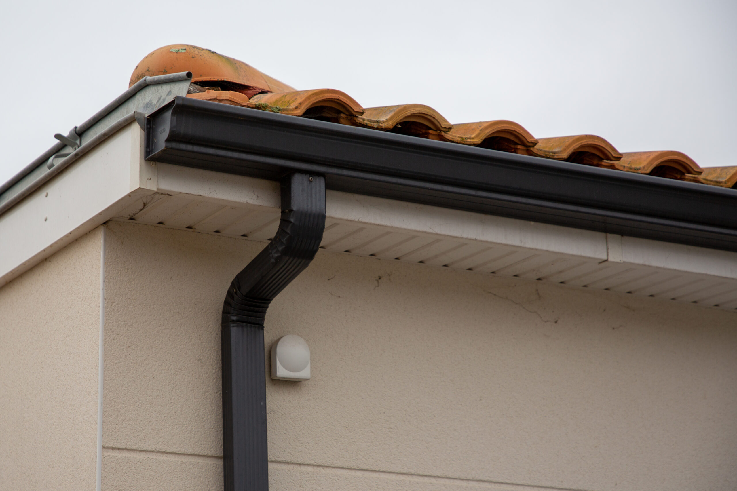 Metal gutter on roof with ceramic tiles