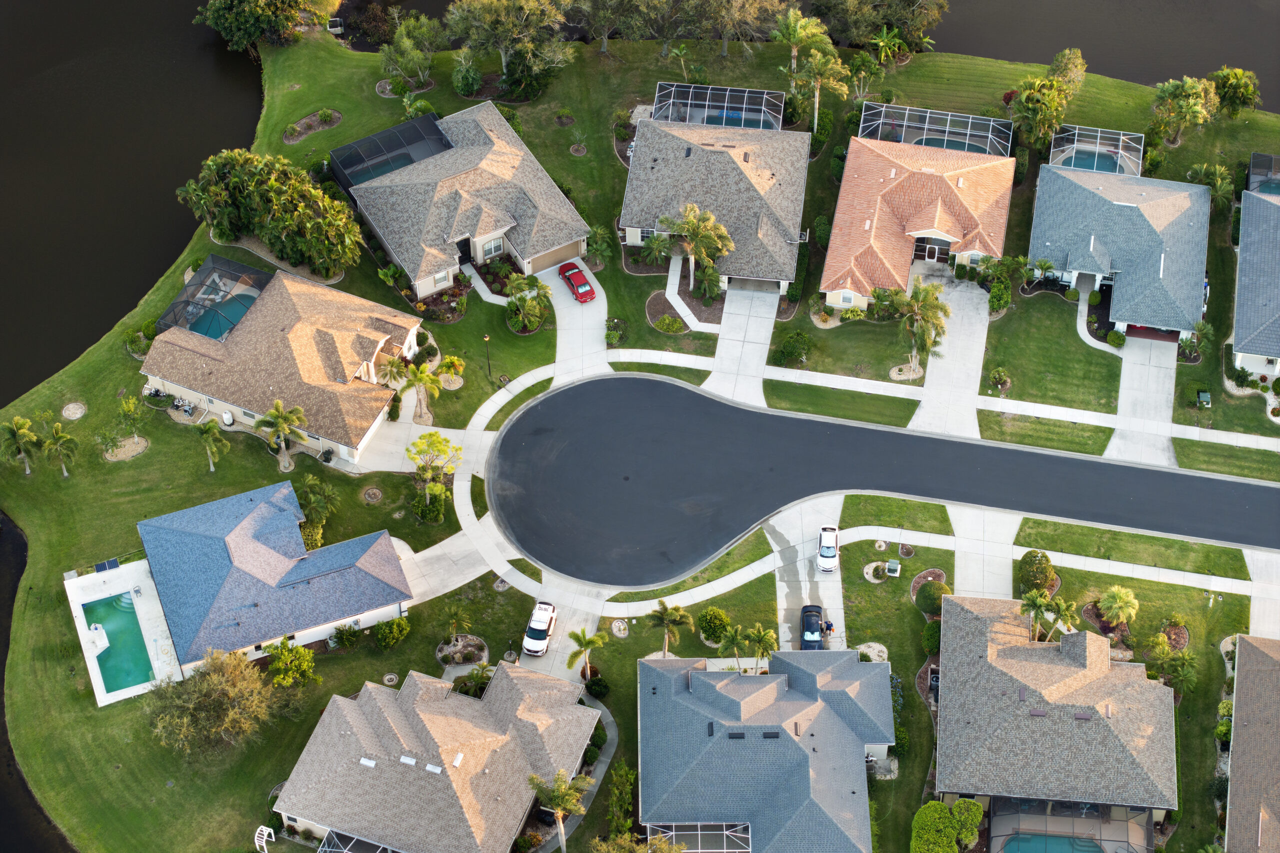 Aerial view of residential Florida homes with various roof types under summer sunlight